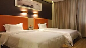 A hotel room with two beds, each with white bedding and orange headboards. There is a framed picture on the wall above the beds and a curtain on the window. - Enjoy staying at Premium Hotel (Zhaoyuan)