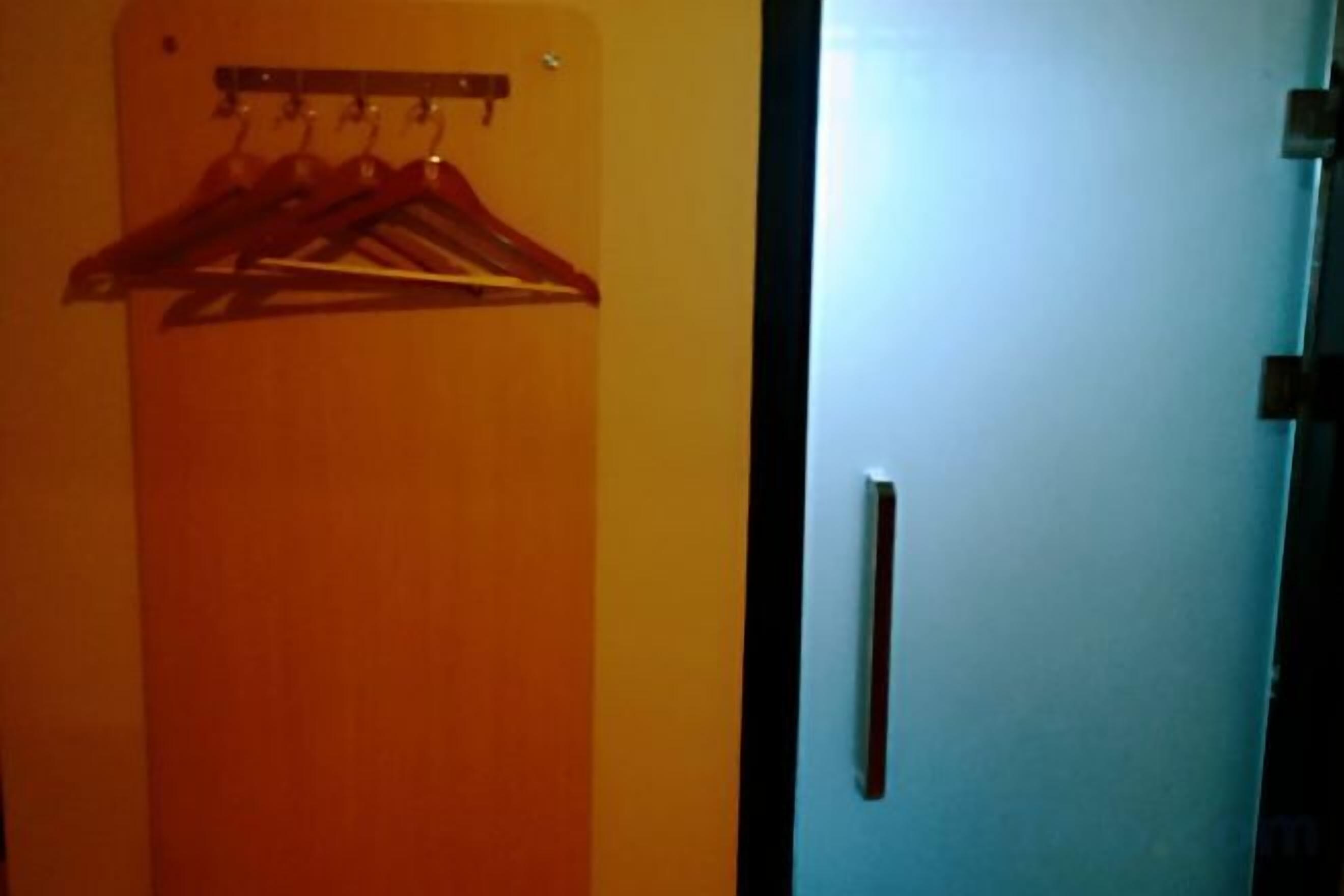 A room with a wooden door and a coat rack with hangers.