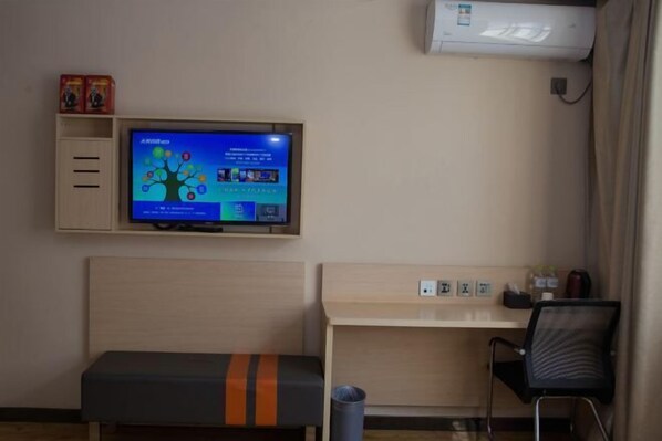 A hotel room with a bed, a desk, a chair, a TV mounted on the wall, and a trash bin. - Home Inn Yihé Hotel (Yantai Zhaoyuan Puzhao Road Nandu Lijing Branch) (Zhaoyuan)