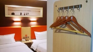 A hotel room with two beds, a bedside table with a phone, and a wall-mounted coat rack with hangers. - Home Inn Yihé Hotel (Yantai Zhaoyuan Puzhao Road Nandu Lijing Branch) (Zhaoyuan)