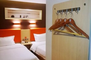 A hotel room with two beds, a bedside table with a phone, and a wall-mounted coat rack with hangers. - Home Inn Yihé Hotel (Yantai Zhaoyuan Puzhao Road Nandu Lijing Branch) (Zhaoyuan)