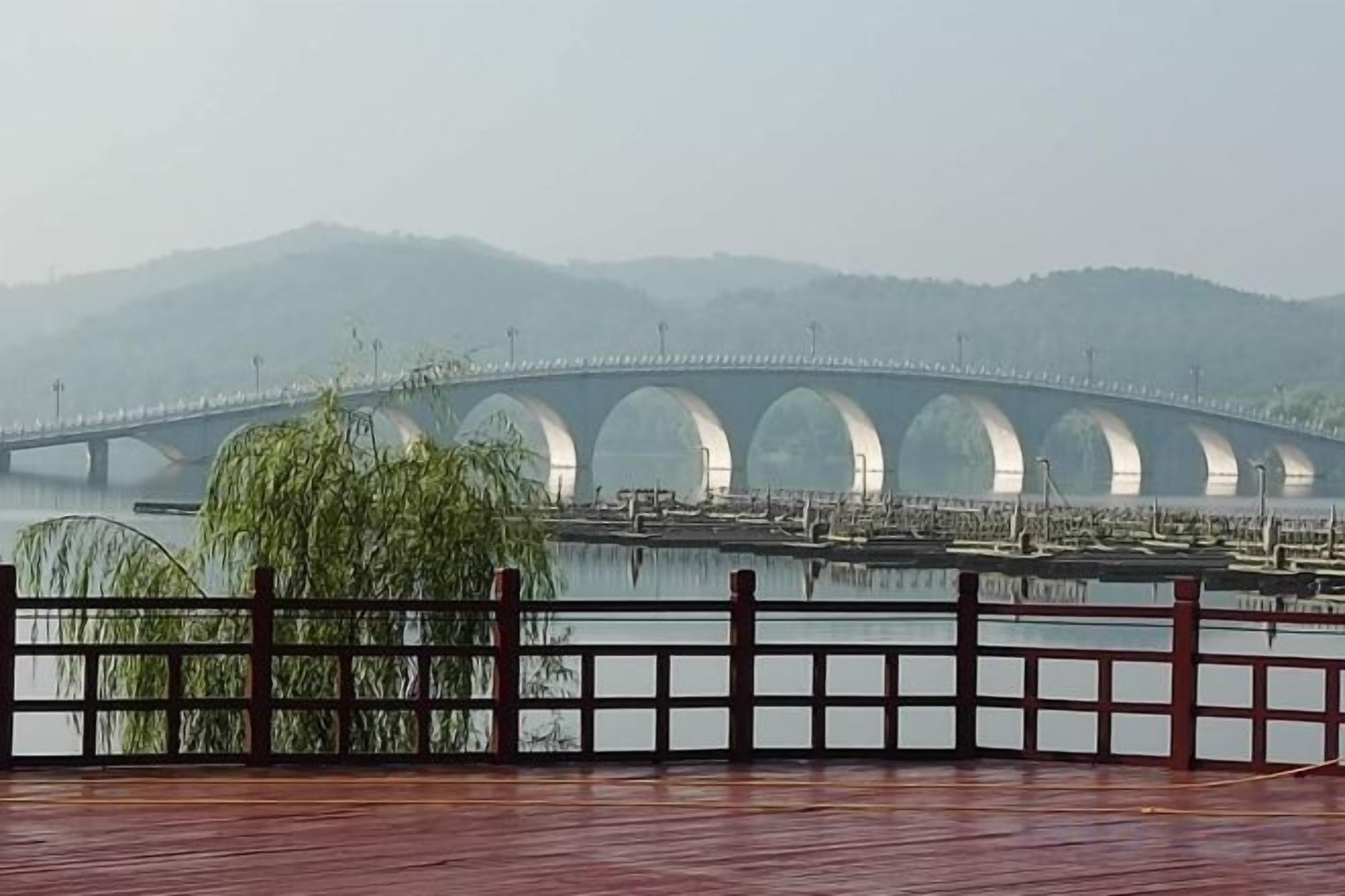 A bridge over a body of water with a wooden deck in the foreground.
