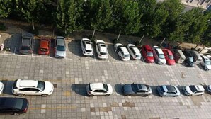 An aerial view of a parking lot with multiple rows of parked cars and a few people walking. - Home Inn Yihé Hotel (Yantai Zhaoyuan Puzhao Road Nandu Lijing Branch) (Zhaoyuan)