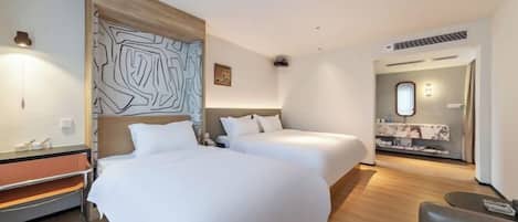 Una habitación de hotel con dos camas, un escritorio y una zona de estar.