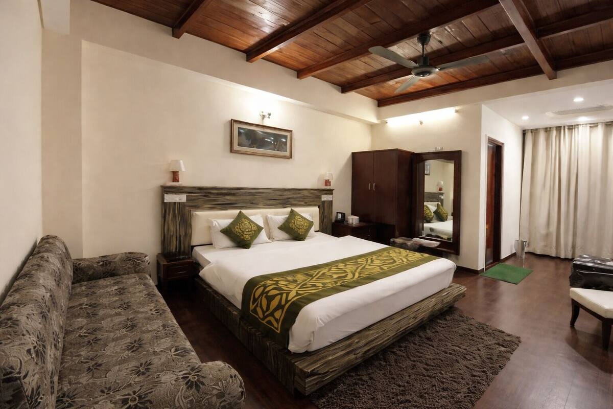 A bedroom with a bed, a nightstand, a dresser, a mirror, a window with curtains, and a wooden ceiling.