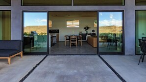 Un intérieur moderne comprenant un coin repas, une cuisine et un espace salon agrémenté de grandes fenêtres.