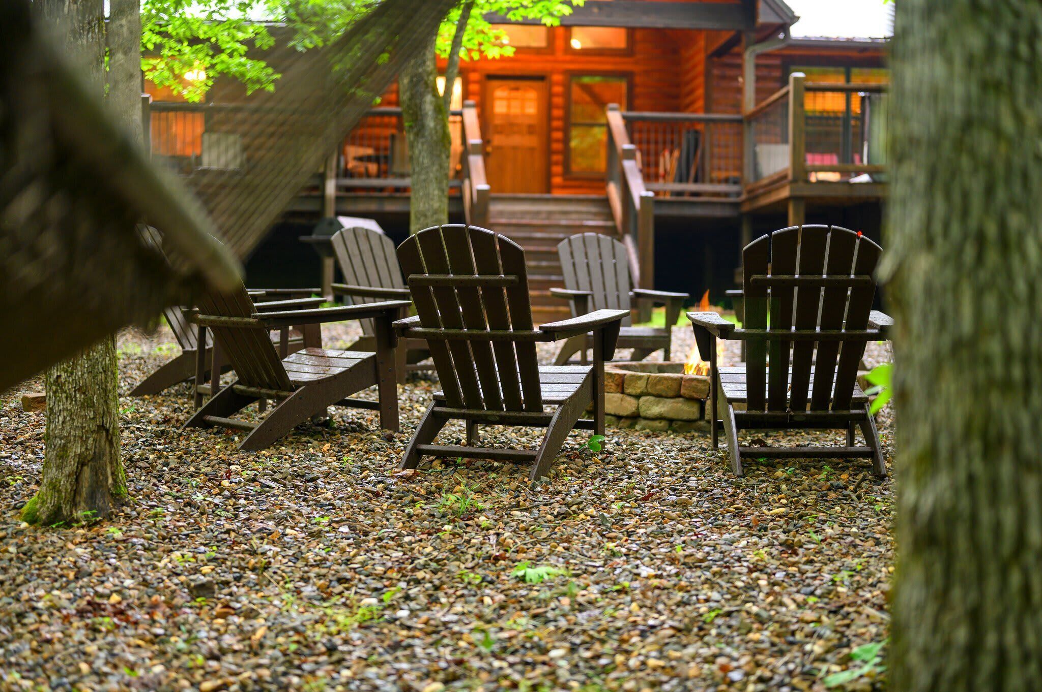 A wooden deck with Adirondack chairs and a fire pit.