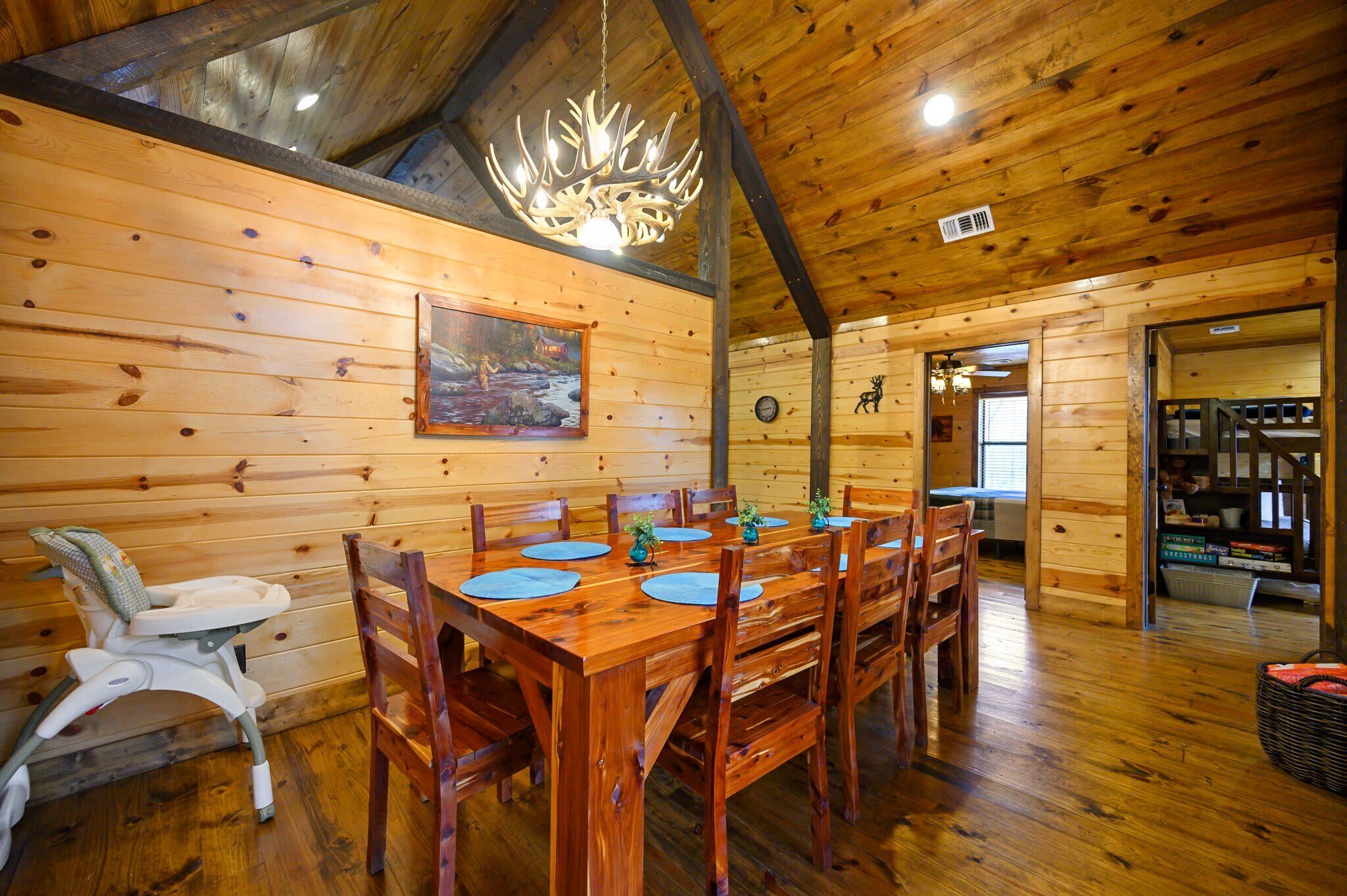 A wooden dining area with a high ceiling and a chandelier.
