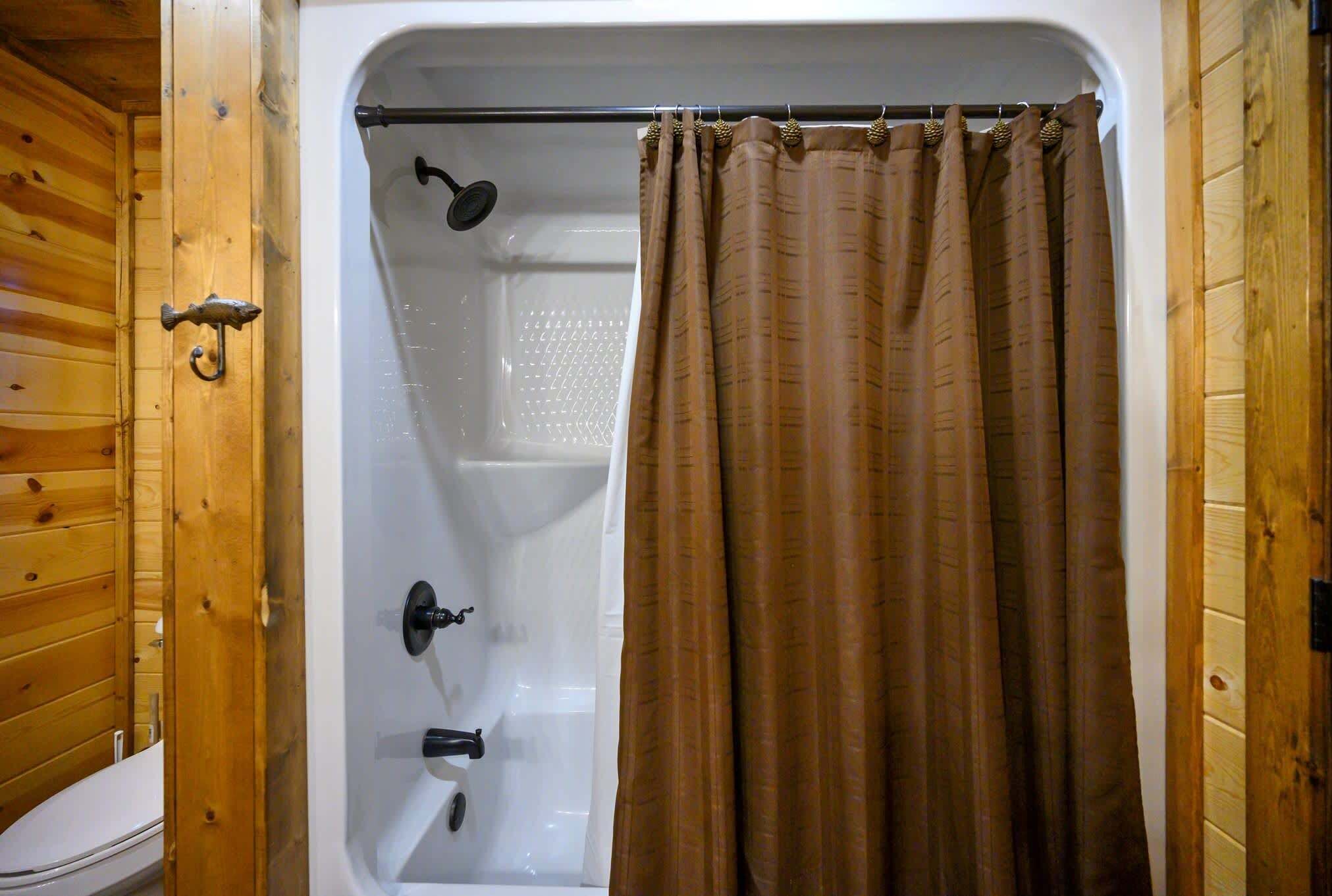 Un intérieur en bois avec une baignoire blanche et un rideau de douche.