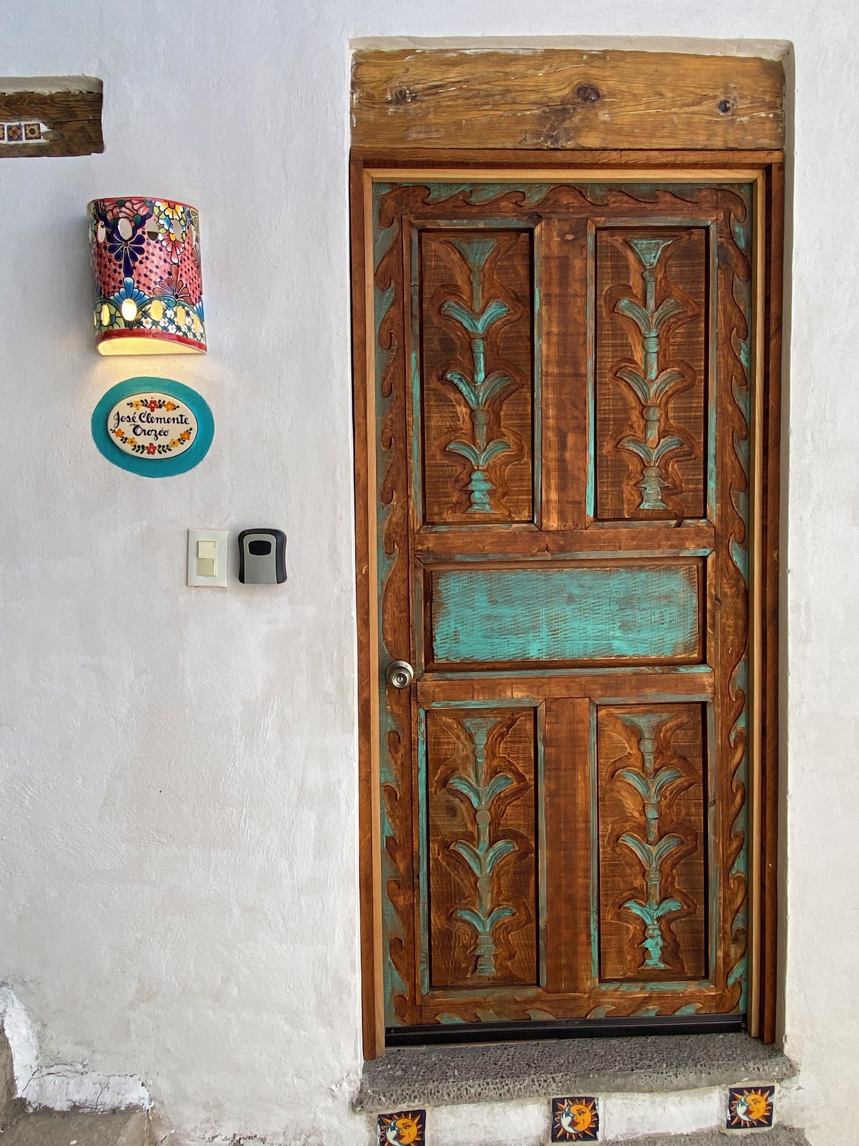 Una puerta de madera con intrincados grabados y una pequeña ventana en la parte superior.
