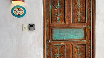 Una puerta de madera con intrincados grabados y una pequeña ventana en la parte superior.