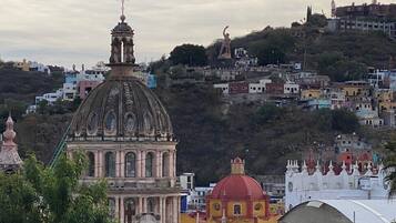 A historic building with a prominent dome and bell tower, surrounded by residential buildings on a hillside.