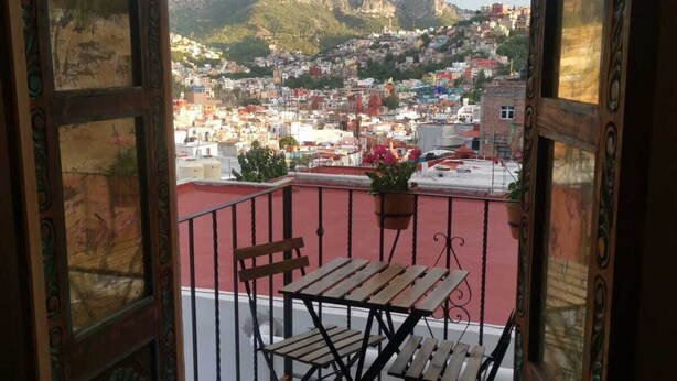Un balcone aperto con vista sulla città e sulle montagne.