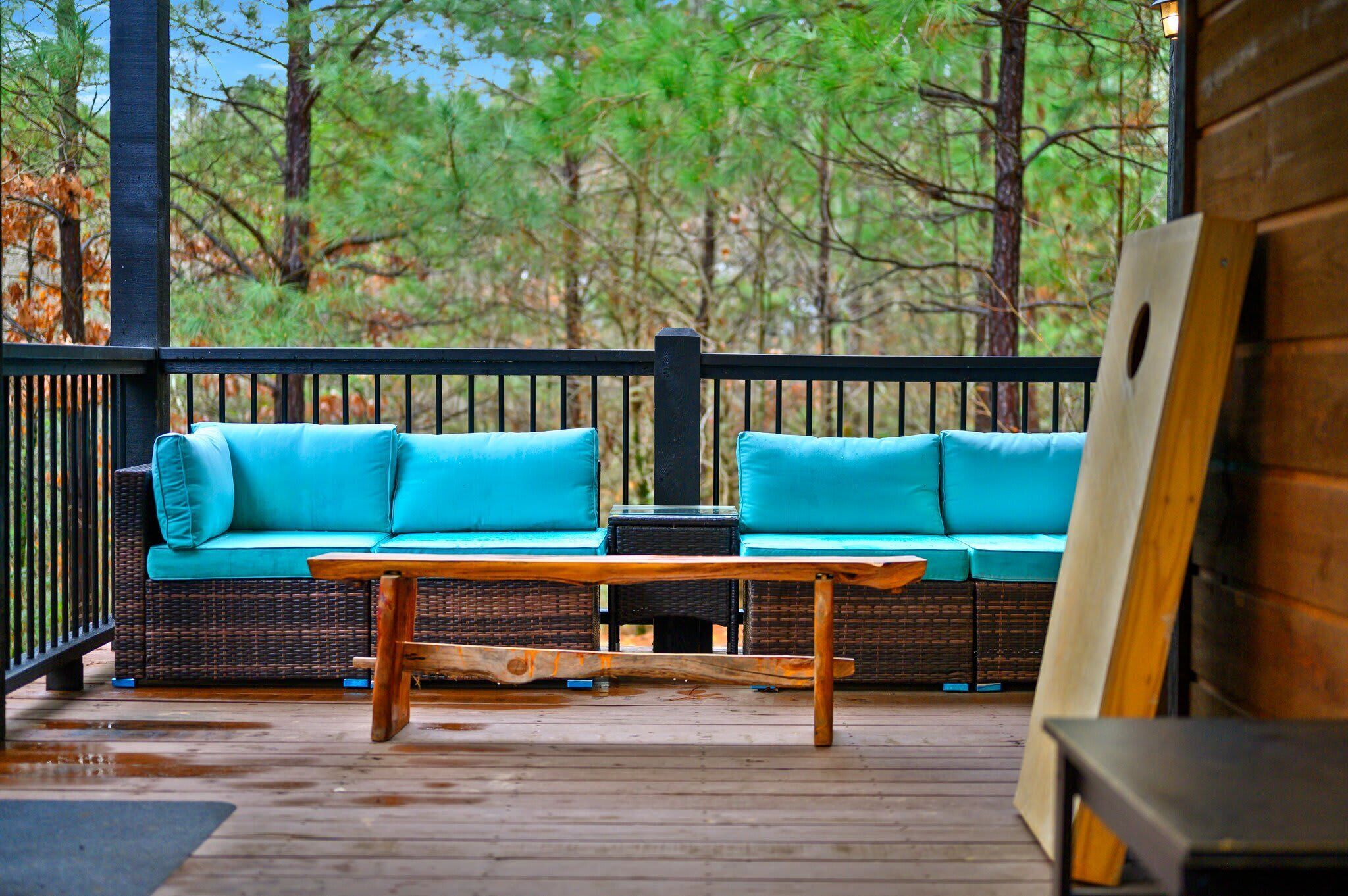 A wooden deck with a wicker sofa and a wooden table.