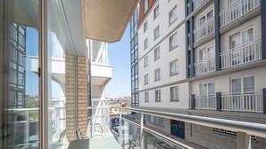 A balcony with a glass railing, a table, and chairs. - Apt by Duinbergen Beach (Knokke-Heist)
