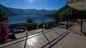 Uma varanda com vista para um lago e montanhas.