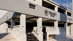 A modern hotel building with a prominent 'Vilano Hotel' sign, featuring a multi-story structure with large windows and a covered entrance. - Villano Hotel (Blumenau)