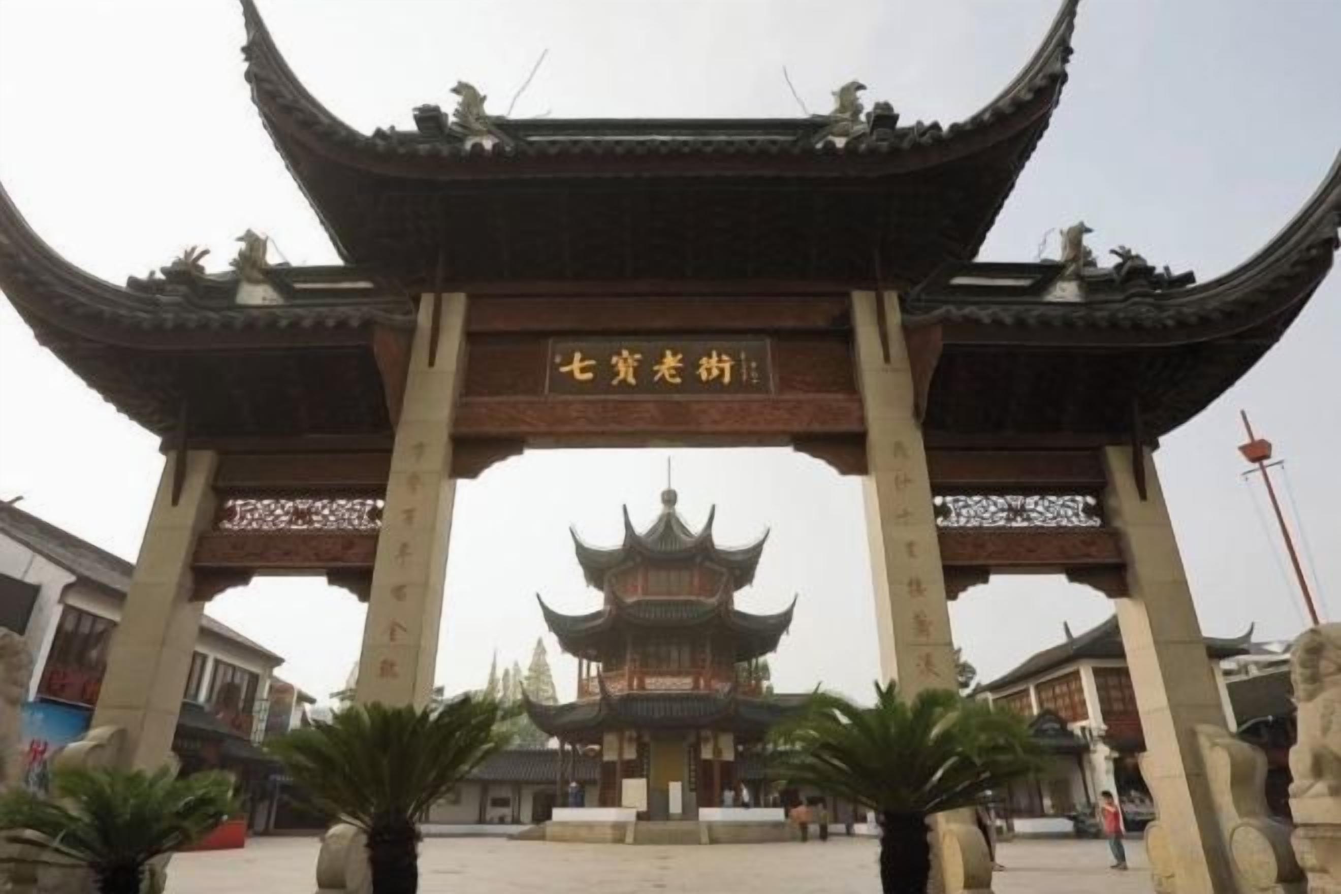 A traditional Chinese gate with a pagoda in the background.