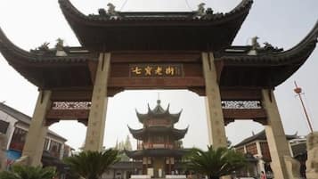 A traditional Chinese gate with a pagoda in the background.