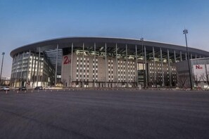 A large, modern stadium with a curved roof and multiple levels of seating. - Minhua Business Hostel (Shanghai)