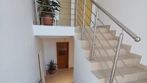 A staircase with metal railings and beige steps leading to a landing.