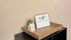 A wall with three mirrors and a sign on a wooden shelf. - Cozy 2-bedroom condo- right beside SCD (Branson)
