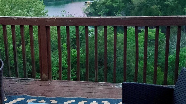 A balcony with a view of a river and forested hills. - Cozy 2-bedroom condo- right beside SCD (Branson)