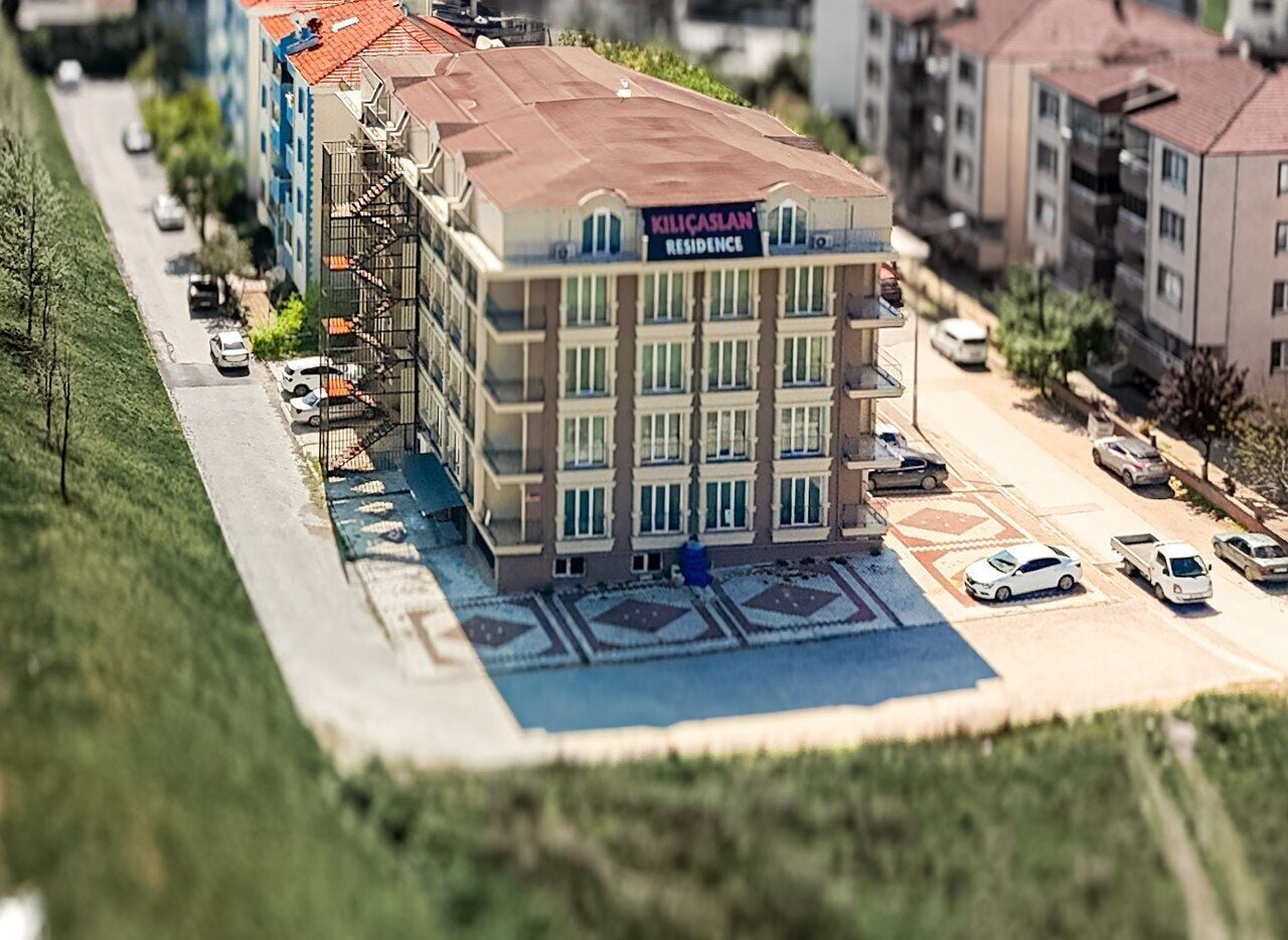 A multi-story building with a sign reading "KILICASLAN RESIDENCE".