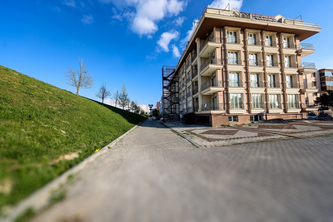 Un hotel de varios pisos con un patio central, balcones y un cielo despejado.