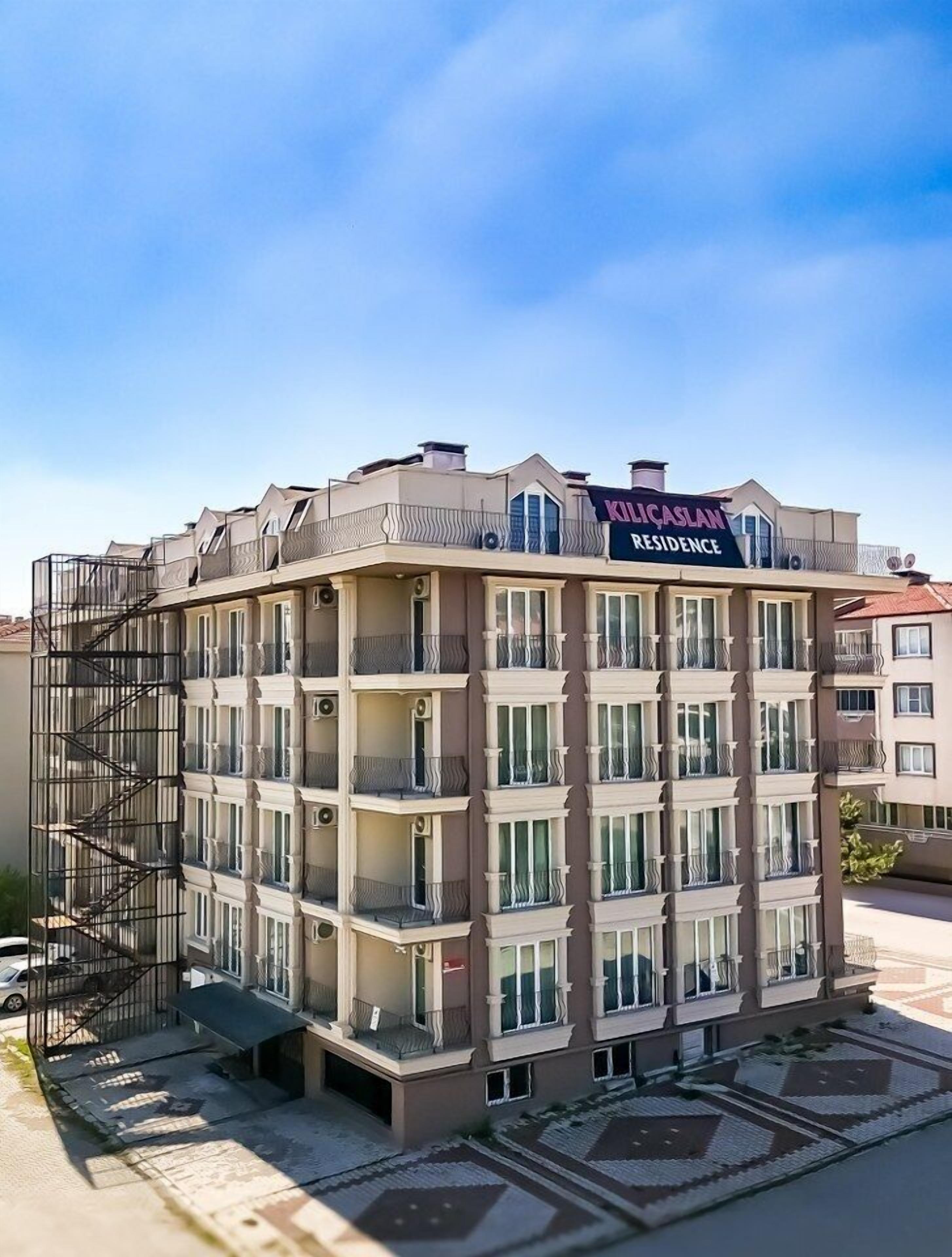 A multi-story building with a sign reading "KILICASLAN RESIDENCE".