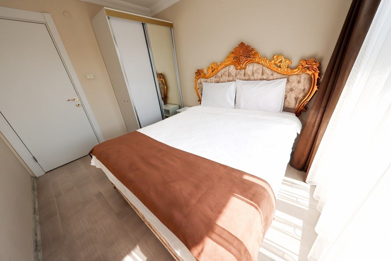 Una habitación de hotel con una cama grande, un armario y un espejo.
