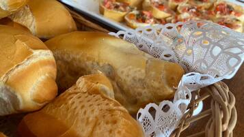 A variety of baked goods including bread rolls and pastries on a table.