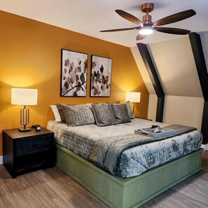 Een slaapkamer met een bed, twee wandlampen en een plafondventilator.