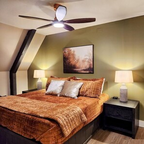 A bedroom with a bed, two nightstands, a ceiling fan, and a painting on the wall. - RockFall Retreat! Nature's Haven (Lancaster)