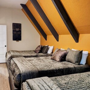 A room with two beds, a basketball hoop, and a door.