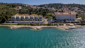 A coastal hotel with multiple modern buildings, a large central building, and a beach area.