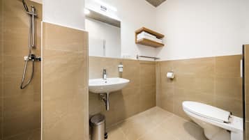 Shower, pengering rambut, handuk, dan tisu toilet