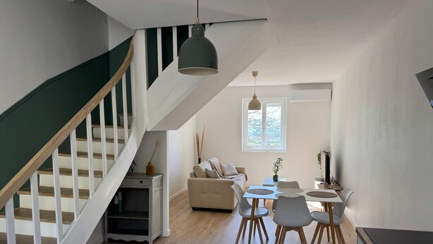 A modern interior with a staircase, dining area, and kitchen. - Village house in the countryside, T3 duplex with master suite. (Ville-sous-Anjou)