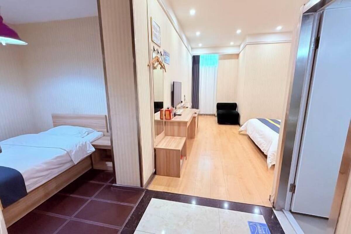 Ein Hotelzimmer mit Bett, Schreibtisch, Sessel und Fernseher.