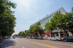 A street with parked cars and trees lining the road. - Yumeida Boutique Hotel Xinxiang Changheng (Changyuan)
