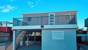 A two-story building with a balcony and a staircase leading to the upper level.