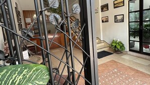 Un intérieur moderne agrémenté d’une porte en métal, de plantes d’intérieur et d’un sol carrelé.