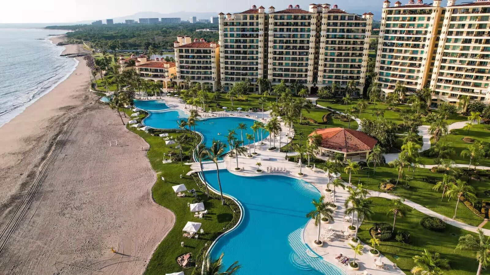 Un complexe hôtelier doté de plusieurs piscines, d’une plage et d’immeubles de grande hauteur.