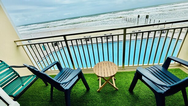 Ein Balkon mit Pool, zwei Stühlen und einem kleinen Tisch.