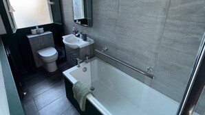 A modern bathroom with a bathtub, sink, and toilet. - Ayr Town Centre Apartment - 3 Bedrooms (Ayr)