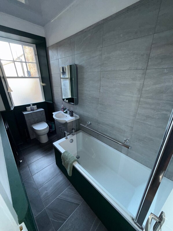 Un baño moderno con bañera, lavamanos e inodoro.