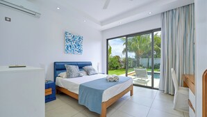 Ein Schlafzimmer mit Bett, Schreibtisch, Stuhl und Blick ins Freie.