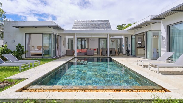 Ein modernes Haus mit Schwimmbad, Glasüren und einer Terrassenfläche.