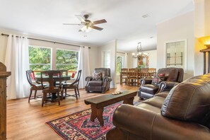 A spacious living room with a fireplace, a dining area, and a view of the outdoors.