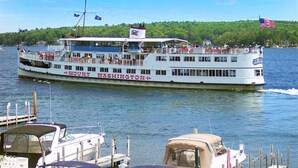 A large riverboat with "Mount Washington" written on its side, docked at a pier with other boats. - Chestnut Cove Cottage- Winnipesaukee - Alton (Alton)
